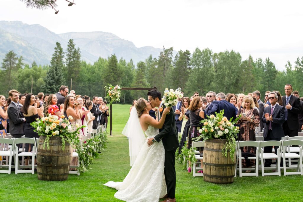 bride and groom kiss after getting married at teton pines country club