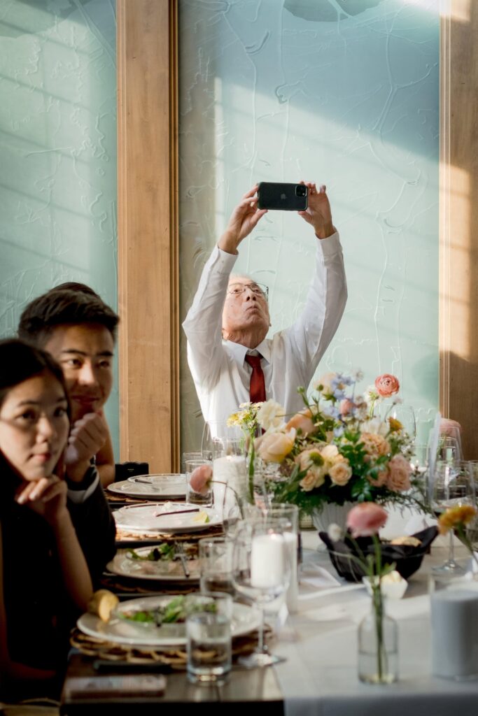 guest takes photo during wedding speeches