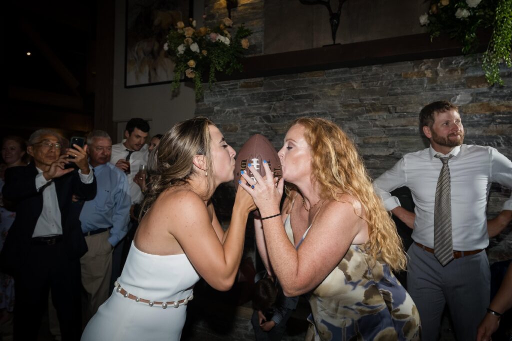 bride and friend kiss football