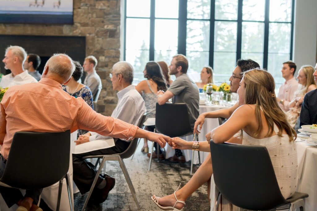 bride holding her dad's hand at welcome dinner in jackson hole