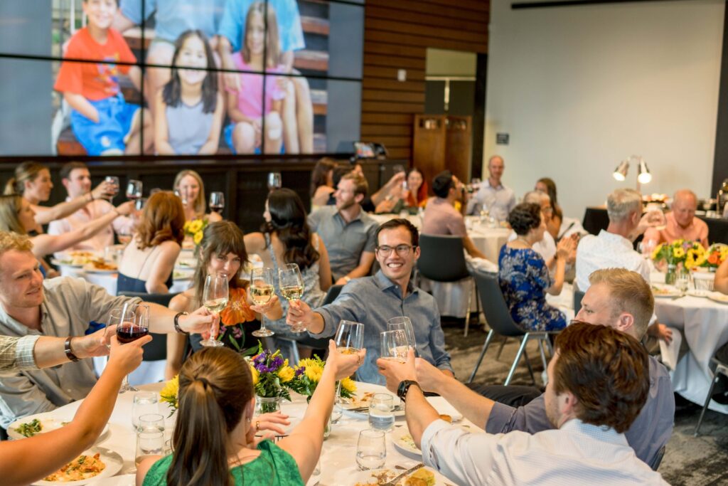 guests cheers at wedding rehearsal dinner