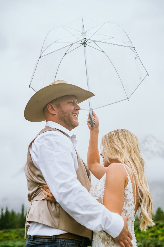 bride and groom with umbrella grand teton wedding portraits