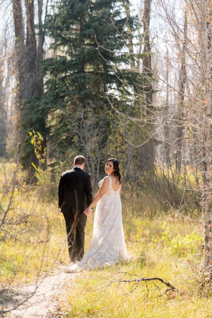 bride and groom walking down trail