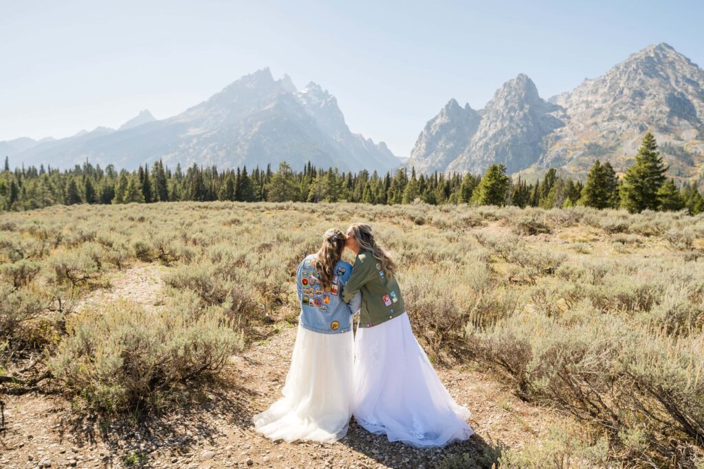 bride and bride touching noses with mountains in back