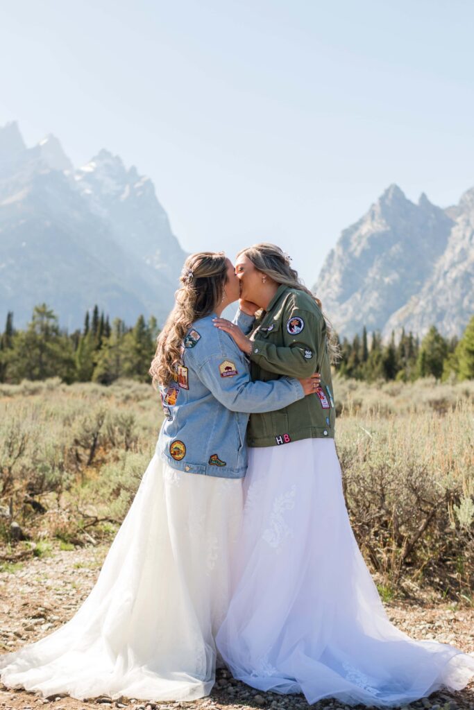 bride and bride touching noses with mountains in back