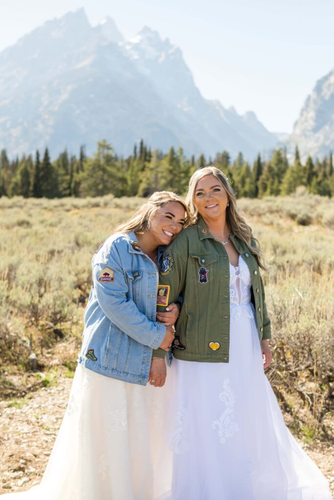 bride and bride snuggling with mountains in back