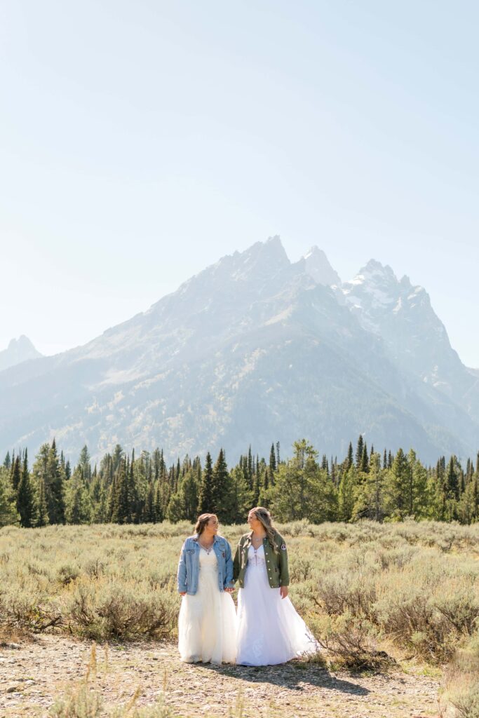 bride and bride holding hands with mountains in back