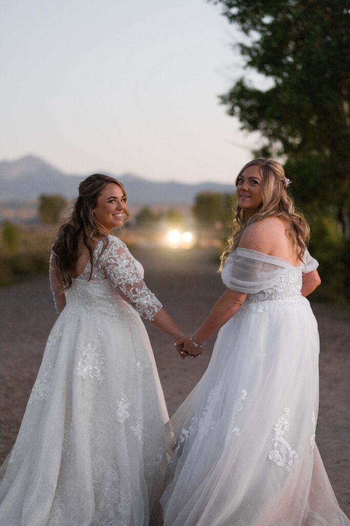 two brides walking together holding hands