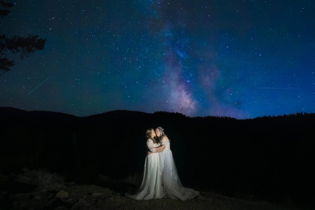 two brides kissing with starry night and teton shadows