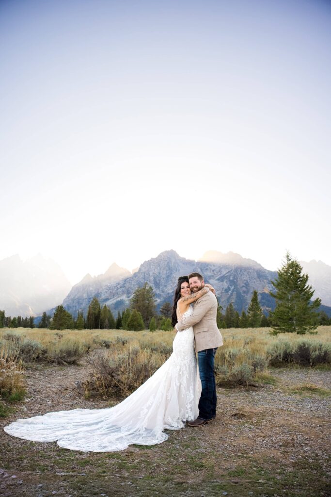 A couple celebrates their wedding with the majestic Grand Teton peaks behind them at Mountain View Turnout.