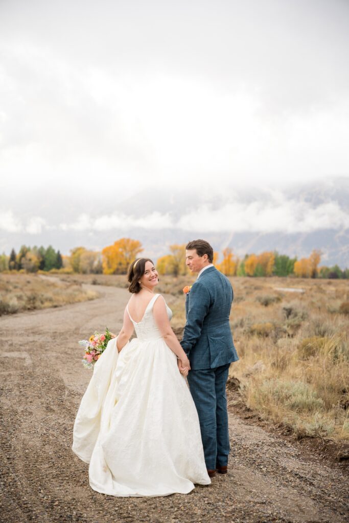 couple smiling at the camera as they enjoy their wedding day in jackson hole