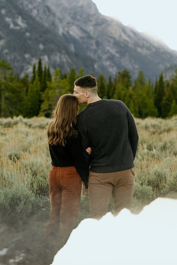 Couple enjoys the view of the mountains while sharing a kiss