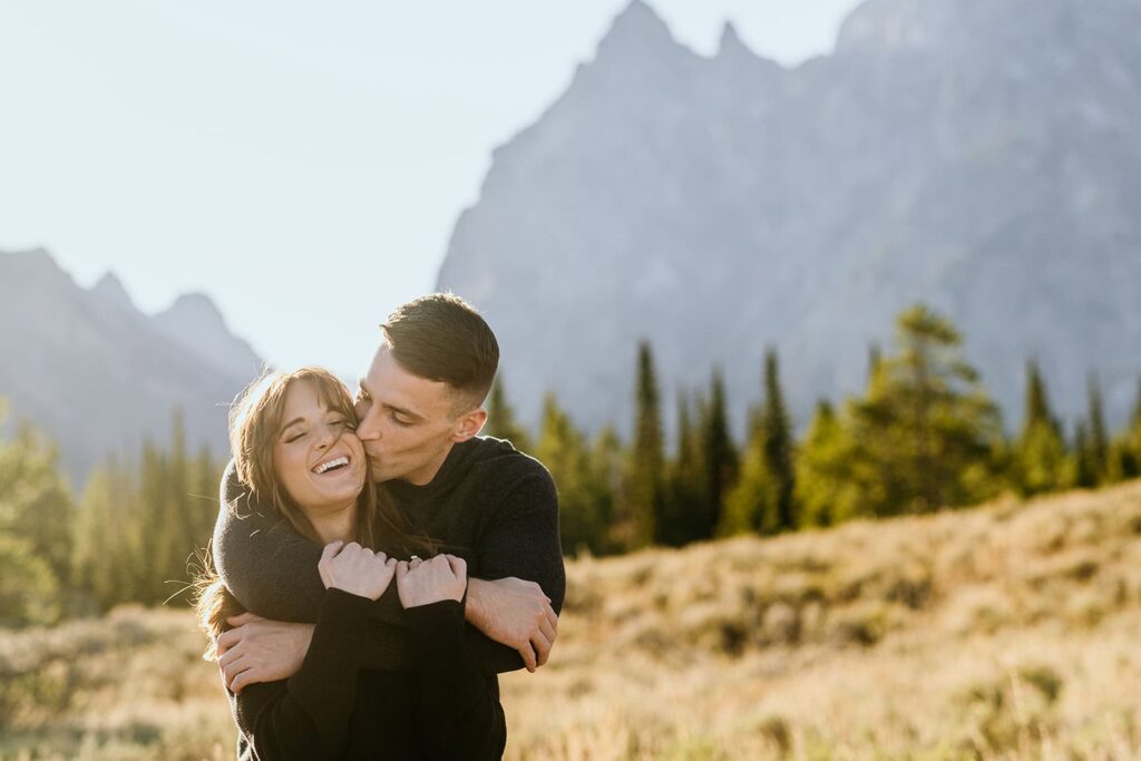 Couple laughing while taking photos in grand teton national park