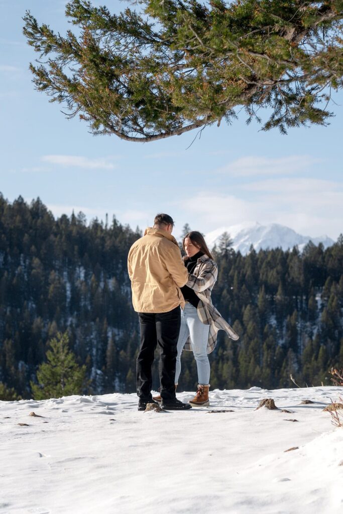 A man is speaking to a woman at the Wedding tree in Grand Teton National Park 
