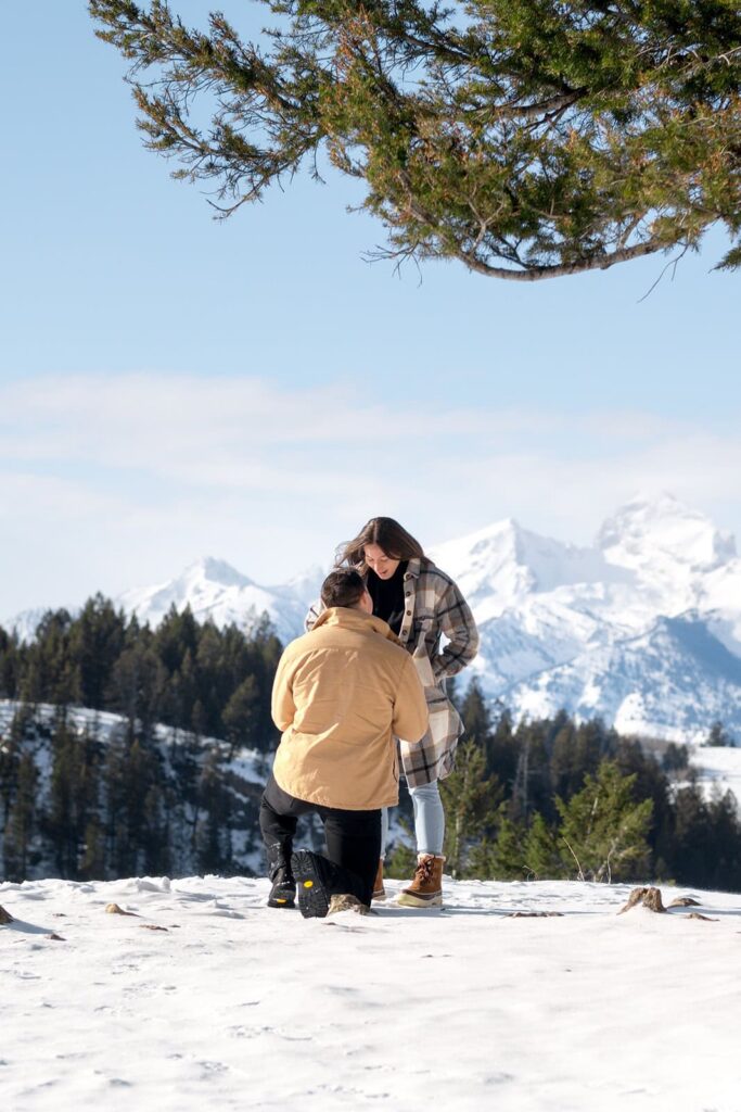 A man proposes to a woman in front of the grand teton mountains in the winter captured by Karina Dopp - A jackson hole wedding photographer